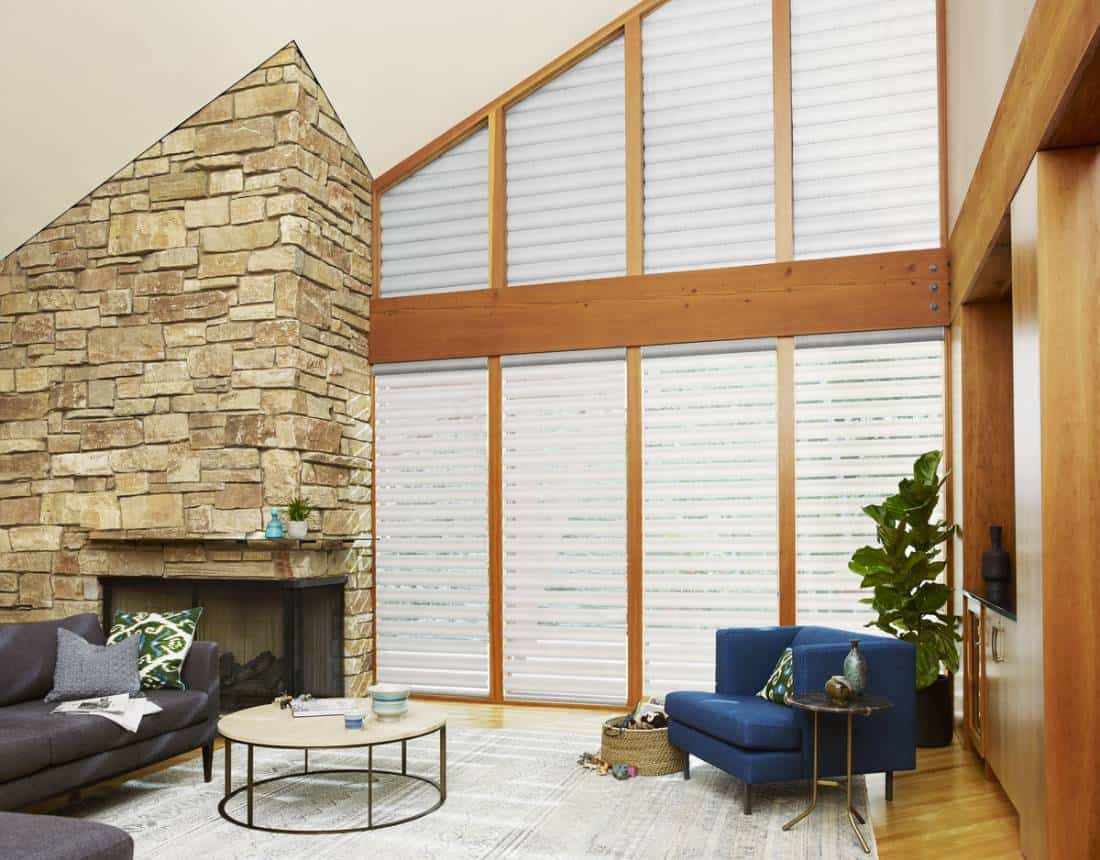 A living room with a fireplace and large windows.