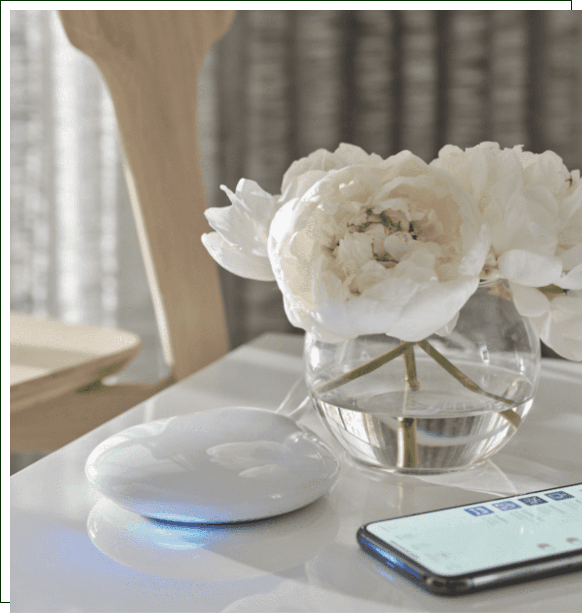 A white table with a phone and flowers on it