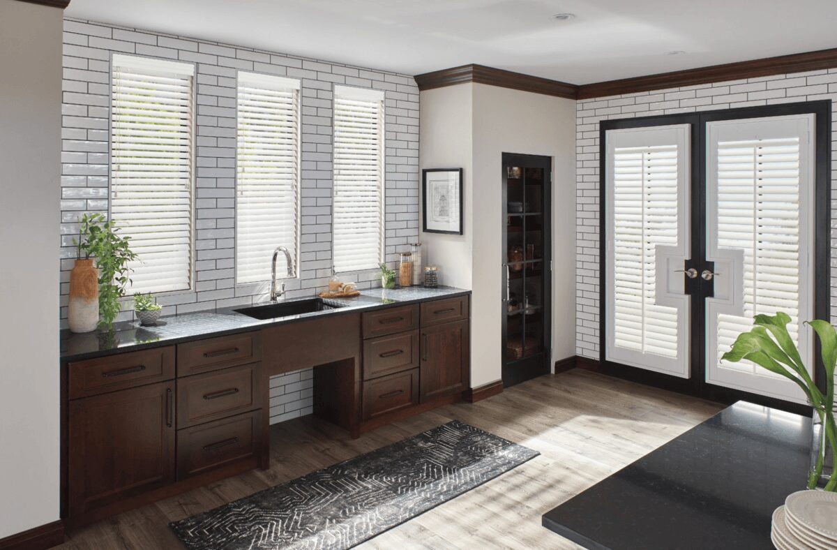 A kitchen with white walls and wooden cabinets.