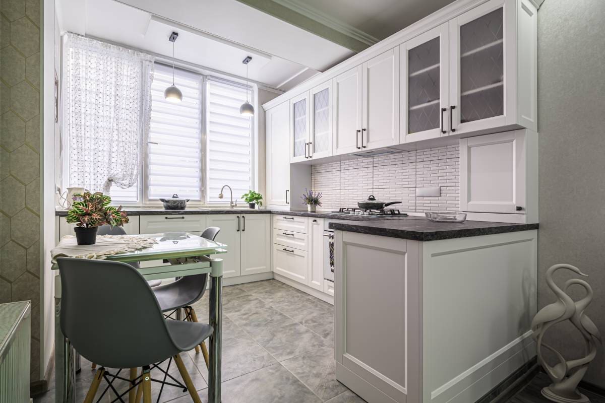 Modern white kitchen with dining table.