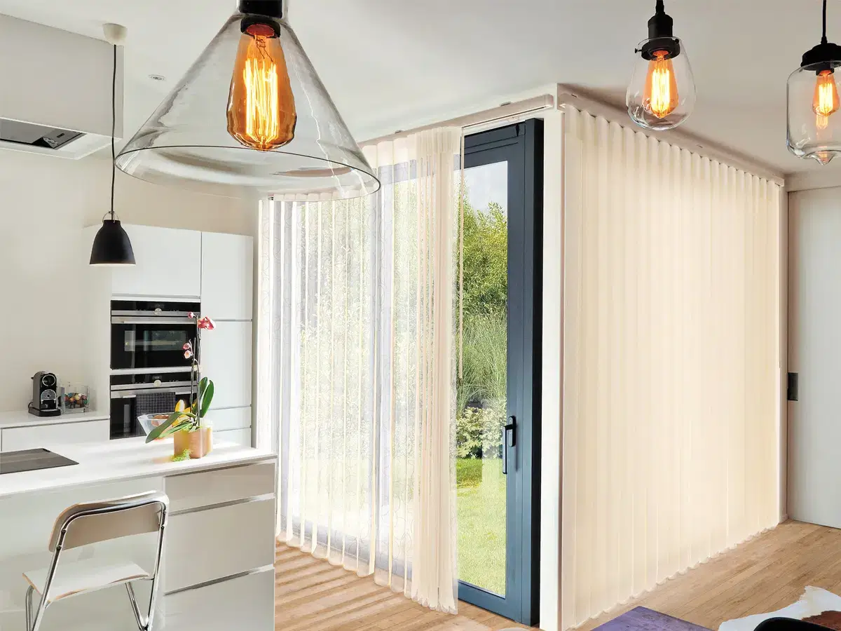 Sunlit kitchen with vertical blinds and pendant lights