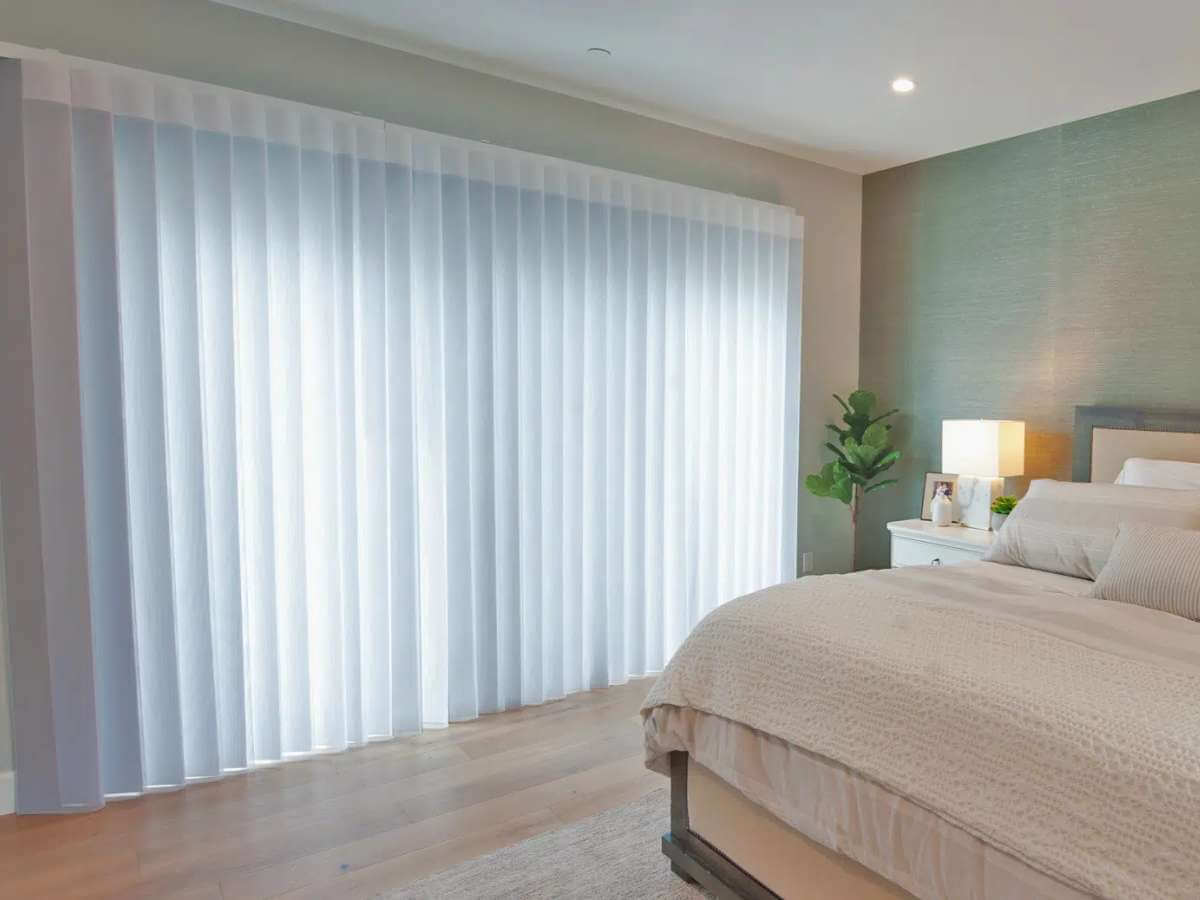 Bright bedroom with vertical blinds and bed