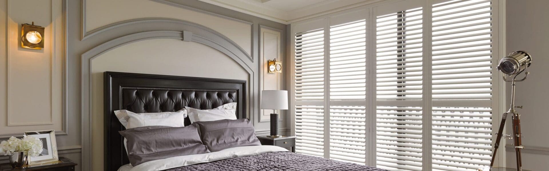 Elegant bedroom with tufted headboard and shutters